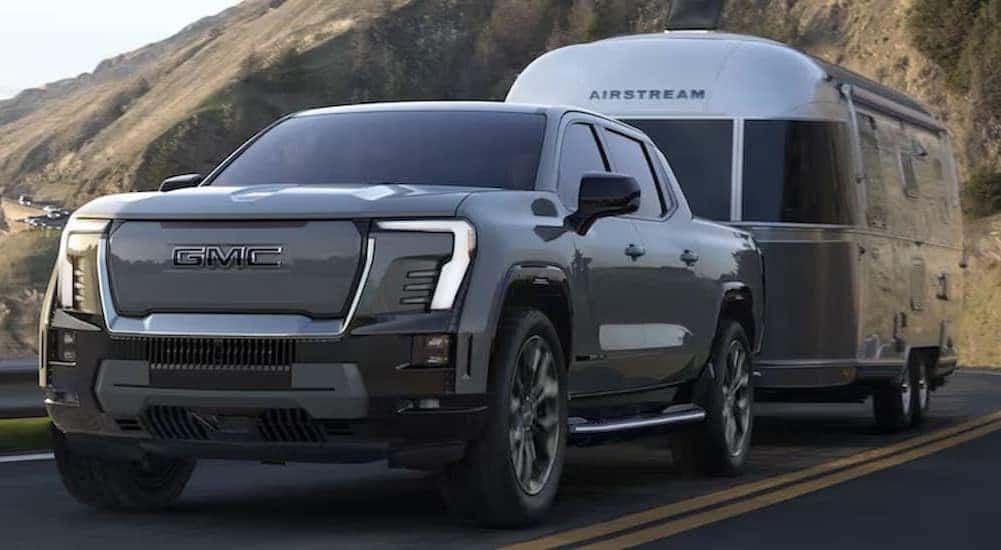 Silver 2026 Chevy Silverado EV towing a camper