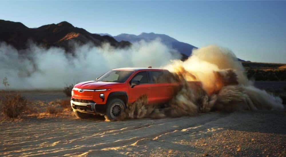 Orange 2026 Chevy Silverado EV driving off-road