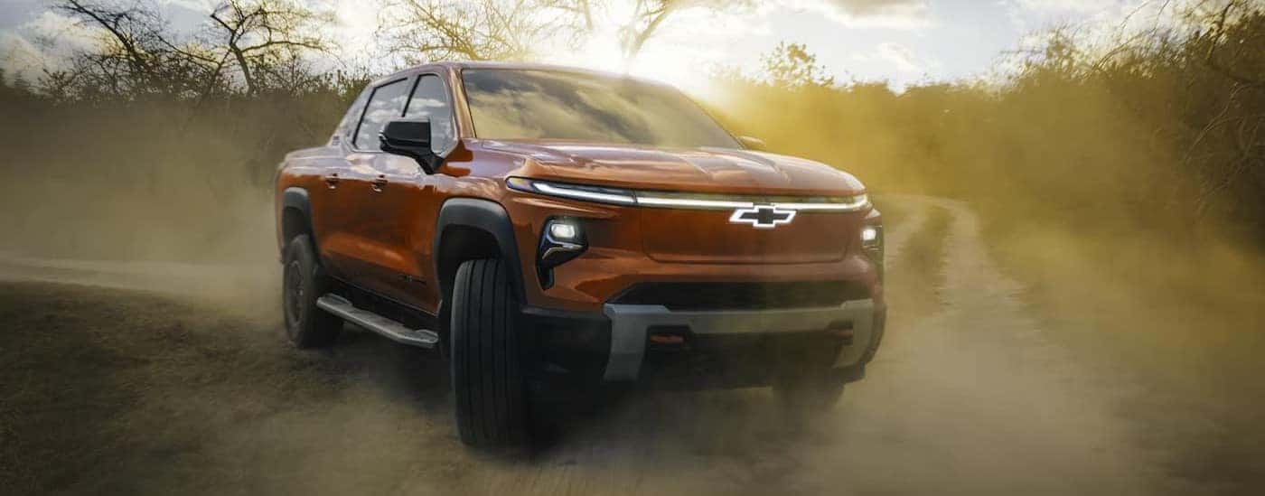A red 2026 Chevy Silverado EV Trail Boss off-roading.