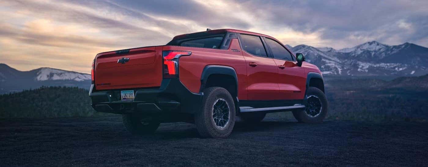 A red 2026 Chevy Silverado EV Trail Boss parked off-road.
