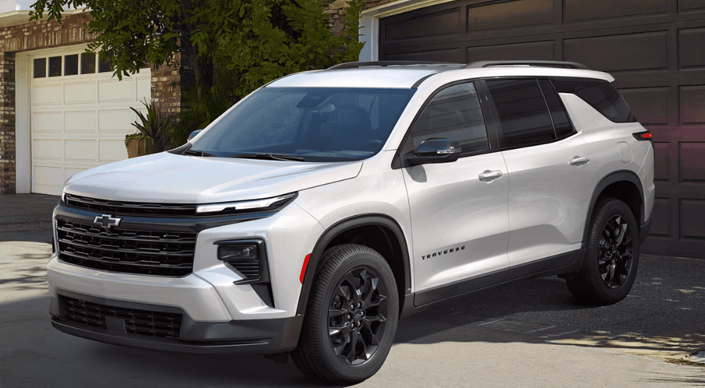 White 2026 Chevy Traverse backed in in front of a garage