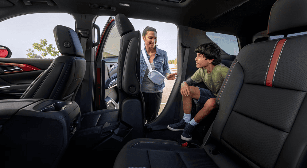 A parent lets a child out of the third row of their 2026 Chevy Traverse