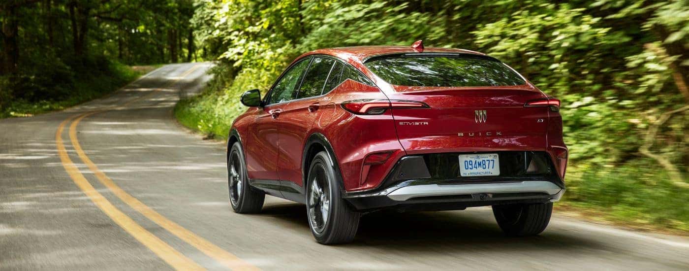 Red 2024 Buick Envista ST driving down the road from the rear