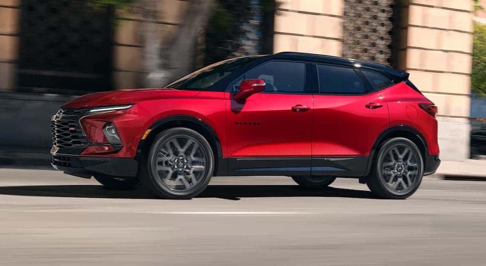 A red 2025 Chevy Blazer RS driving in a city.