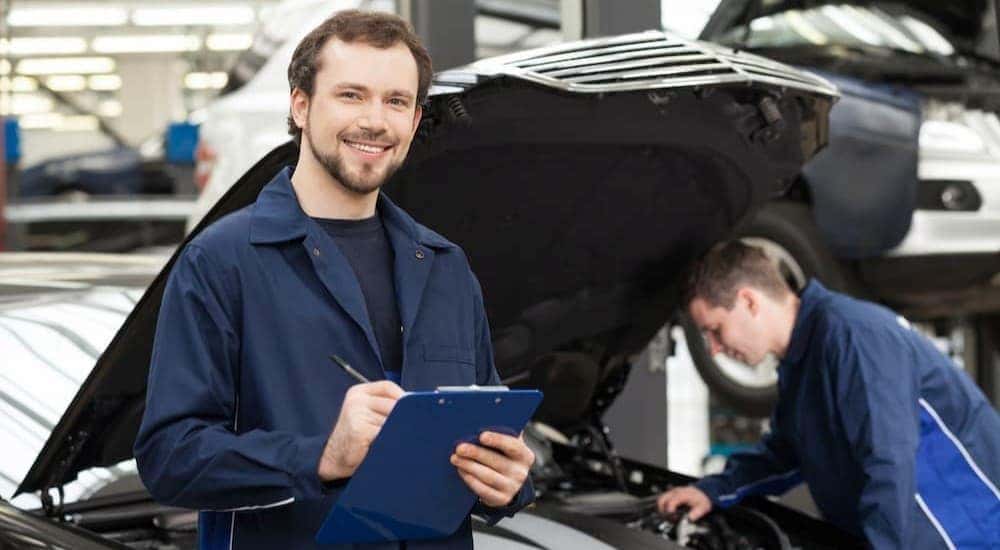 A technician holding a clipboard at a Ford service center near Monroe.