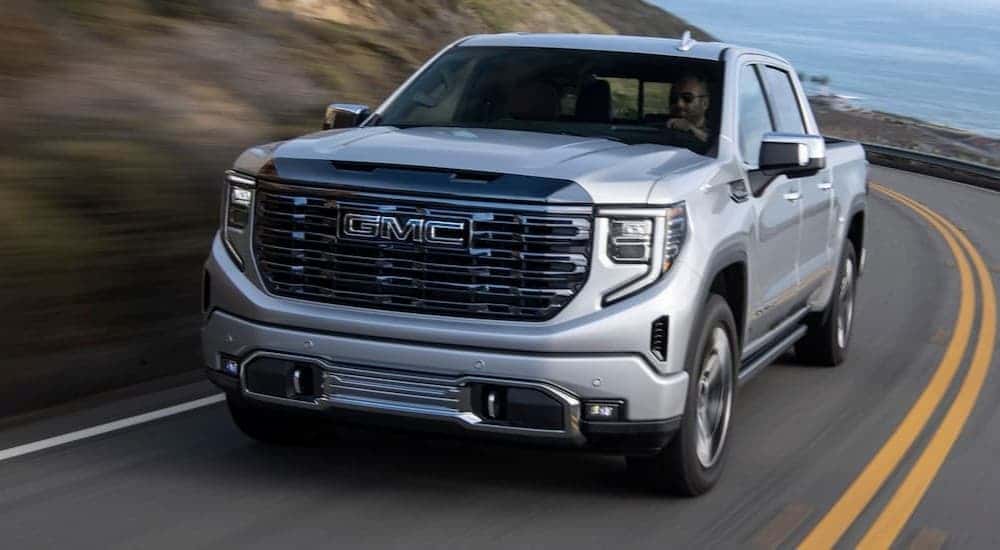 A silver 2024 GMC Sierra 1500 driving to a GMC service center near Monroe.