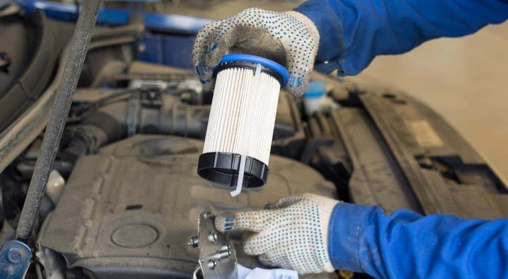 A technician changing a fuel filter.