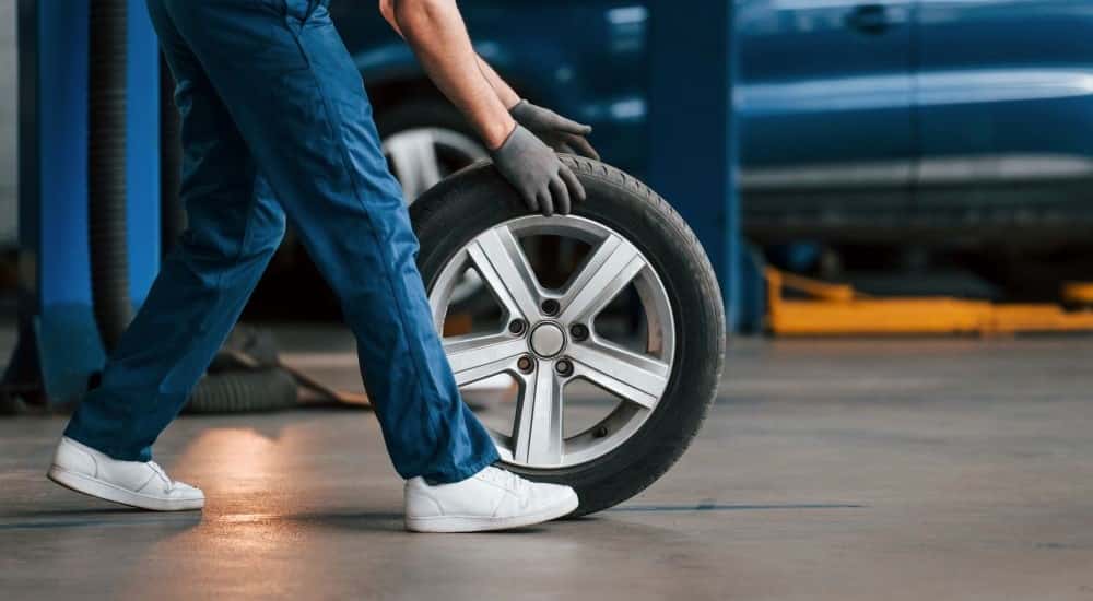 A person rolls a tire inside a Buick Service Center near Monroe