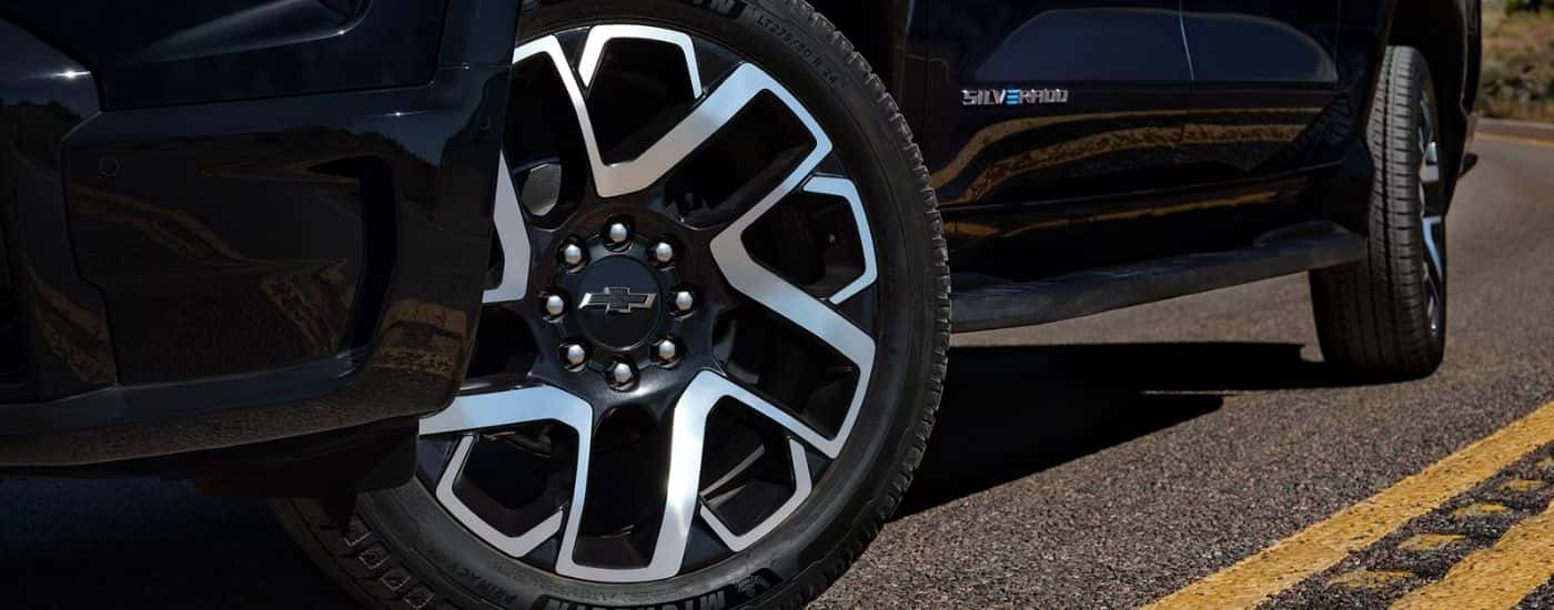 Driver side wheels on a black 2025 Chevy Silverado EV