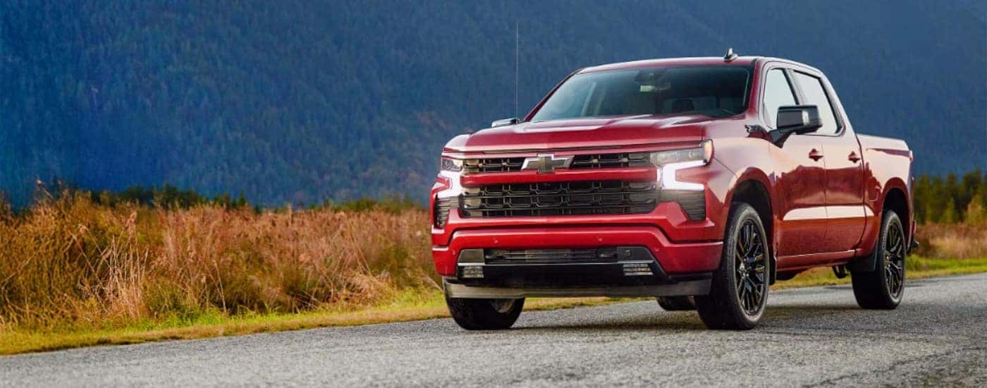 Red 2026 Chevy Silverado 1500 RST driving on a rural road