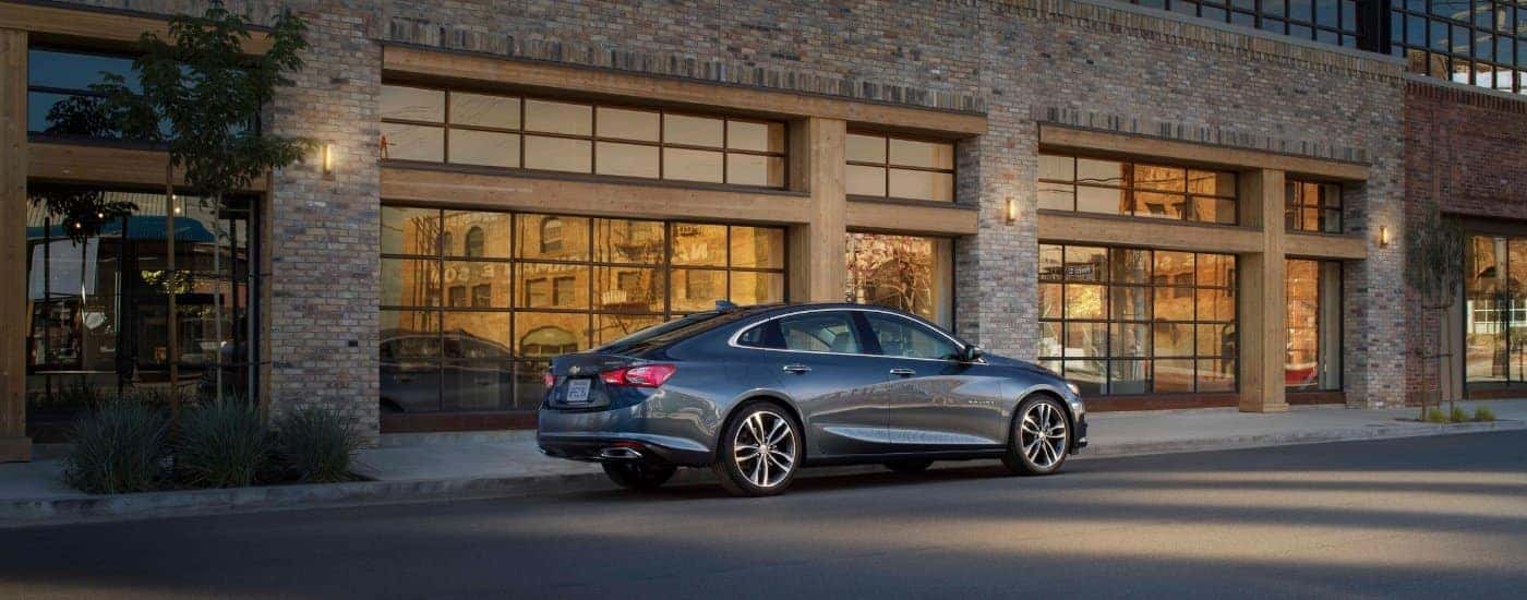 A grey 2019 Chevy Malibu from the side after leaving a dealer with a used Chevy for sale near Loveland.