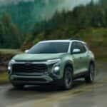 Green 2026 Chevy Equinox RS driving to see a used Chevy for sale near Loveland