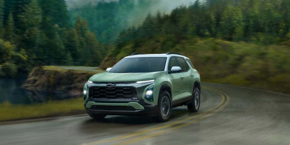 Green 2026 Chevy Equinox RS driving to see a used Chevy for sale near Loveland