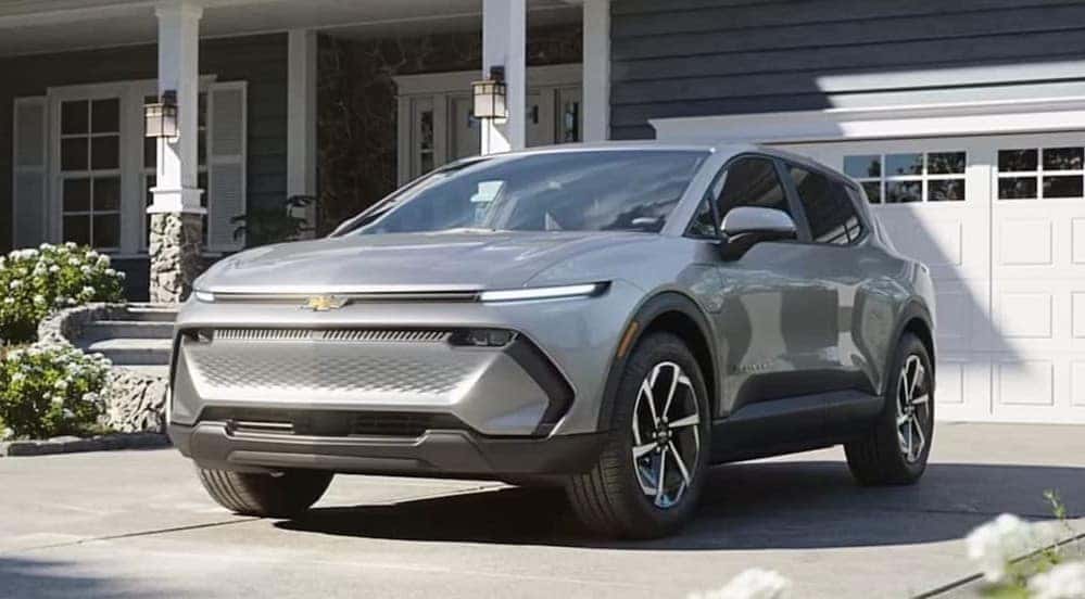 A silver 2026 Chevy Equinox EV parked on a driveway.