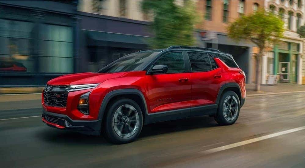 A red 2026 Chevy Equinox driving in a city.