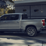 A couple unloading the bed of their silver 2026 Chevy SIlverado 1500 after purchasing a work truck for sale
