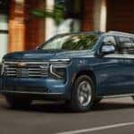 Blue 2026 Chevy Tahoe driving down a city street