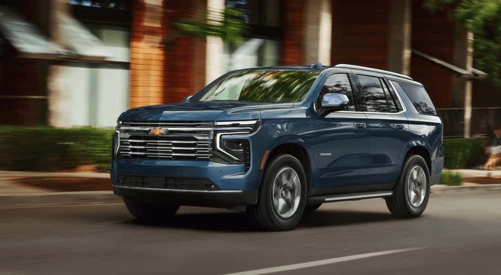 Blue 2026 Chevy Tahoe driving down a city street