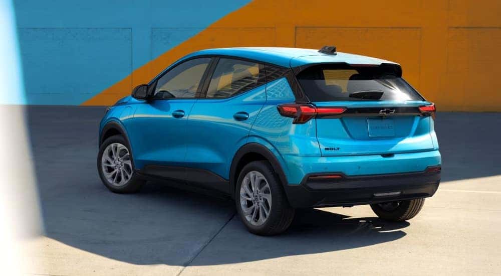 Blue 2027 Chevy Bolt LT parked in front of a multicolored wall