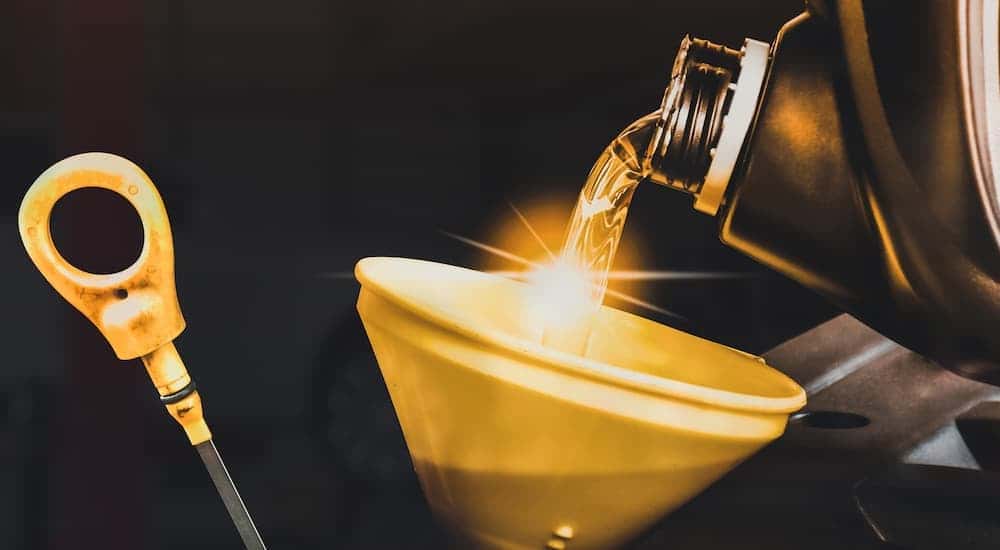 Close-up of an oil can being poured into a funnel.