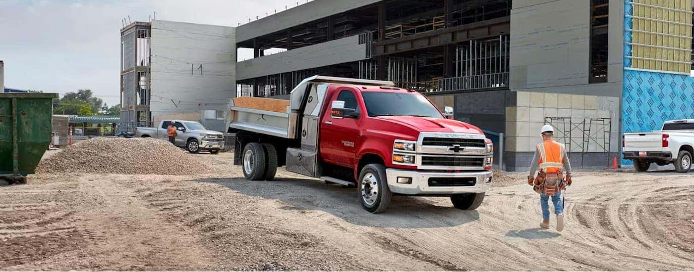 A red 2024 Chevy Silverado 5500 parked on a construction site.
