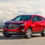 Side of a red 2020 Chevy Equinox parked on pavement.