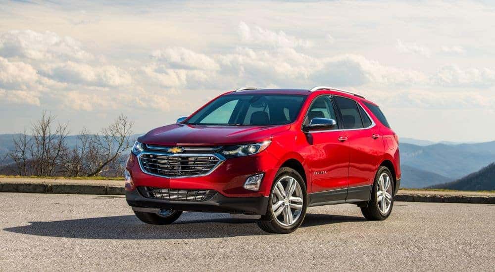 Side of a red 2020 Chevy Equinox parked on pavement.
