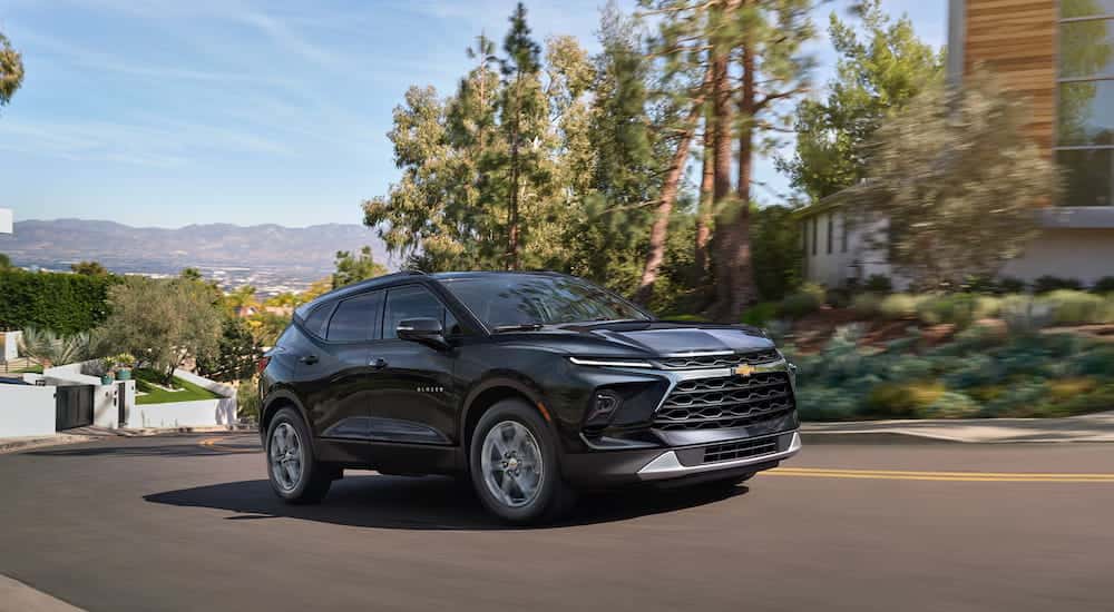 Black 2026 Chevy Blazer driving through a neighborhood.