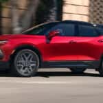 Red 2026 Chevy Blazer driving down a road.