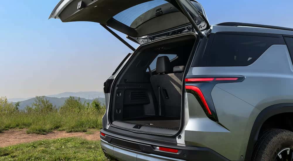 Rear of a green 2026 Chevy Traverse with an open hatch.
