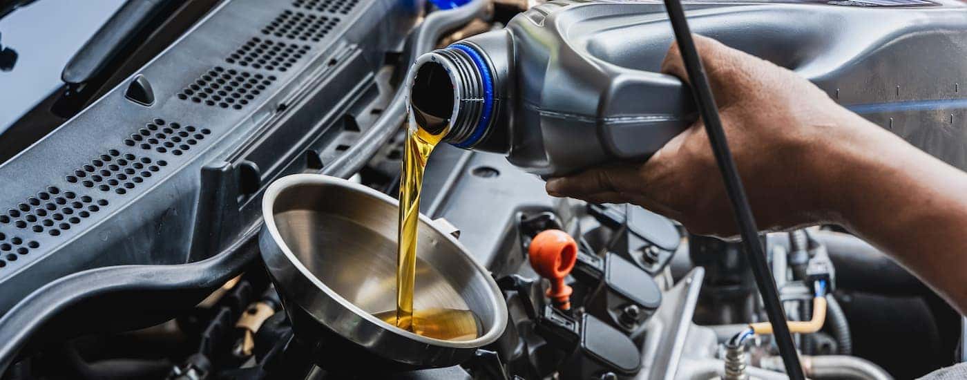 Oil can being poured into a funnel during an oil change near Blue Ash.