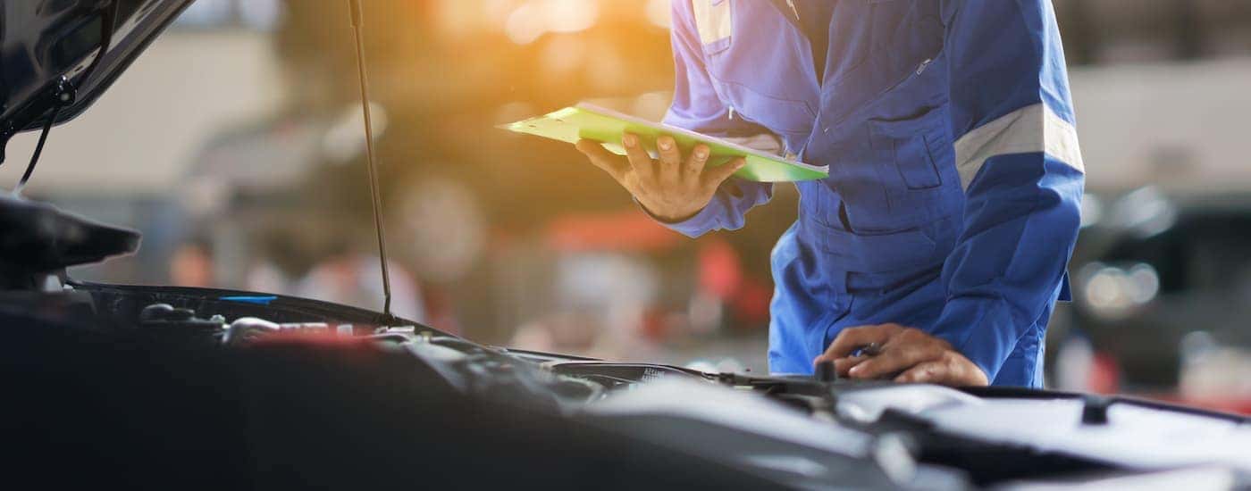 Mechanic examining an engine during an oil change near Dent.