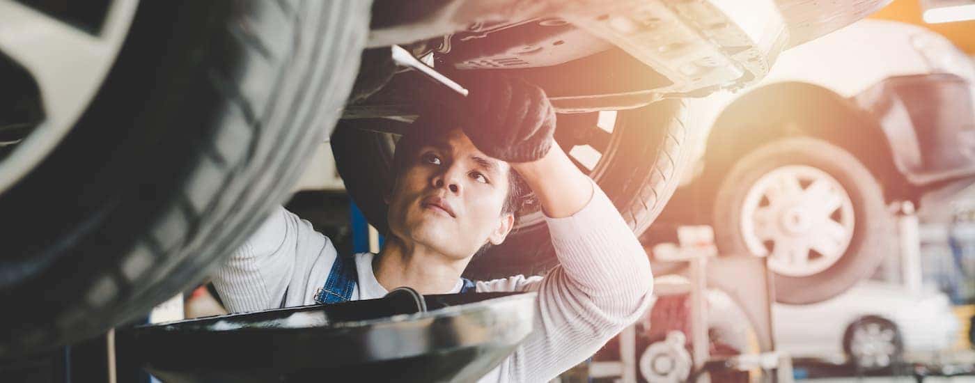 Mechanic working on the underside of an engine.