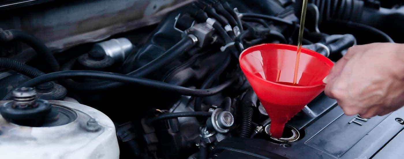 Oil being poured into an engine with a funnel.
