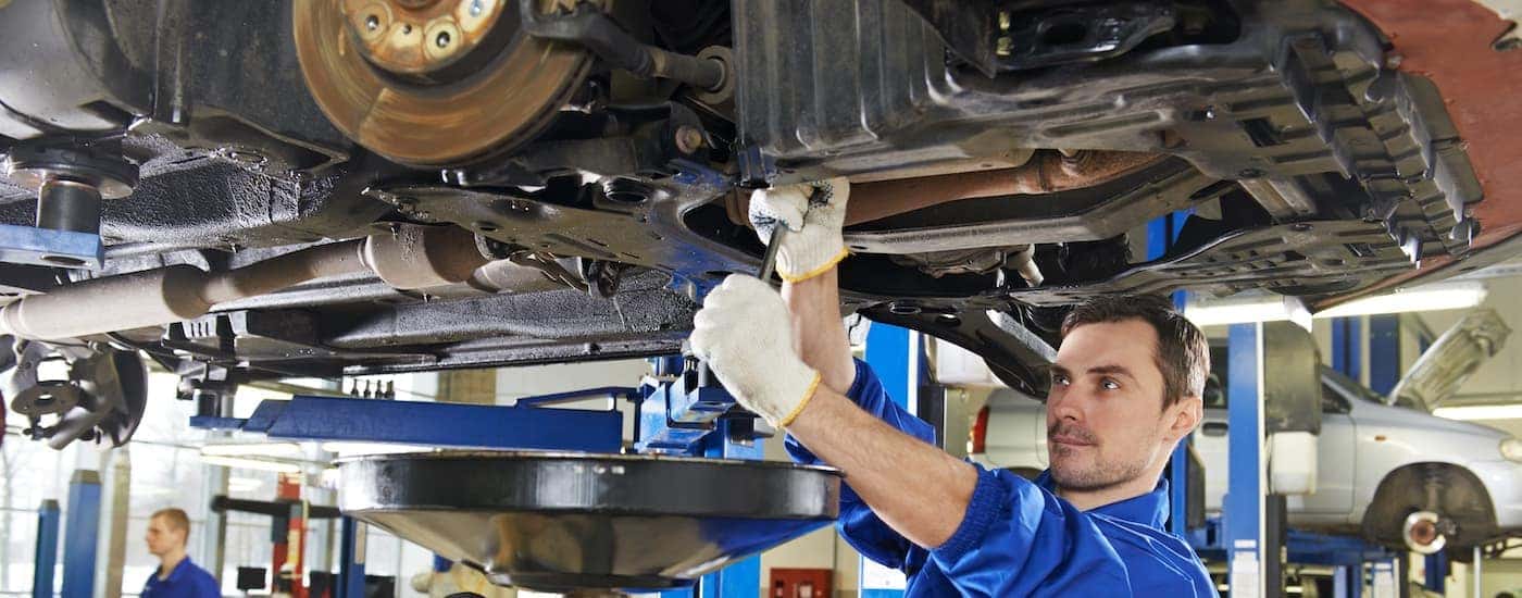 Mechanic performing an oil change on a car.