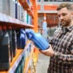 A person looking at an oil container.