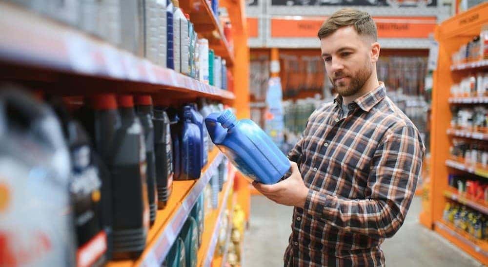 A person looking at an oil container.