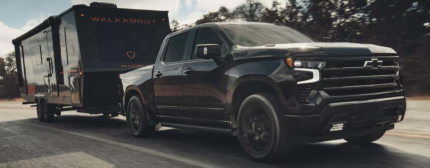 A black 2026 Chevy Silverado 1500towing a trailer.