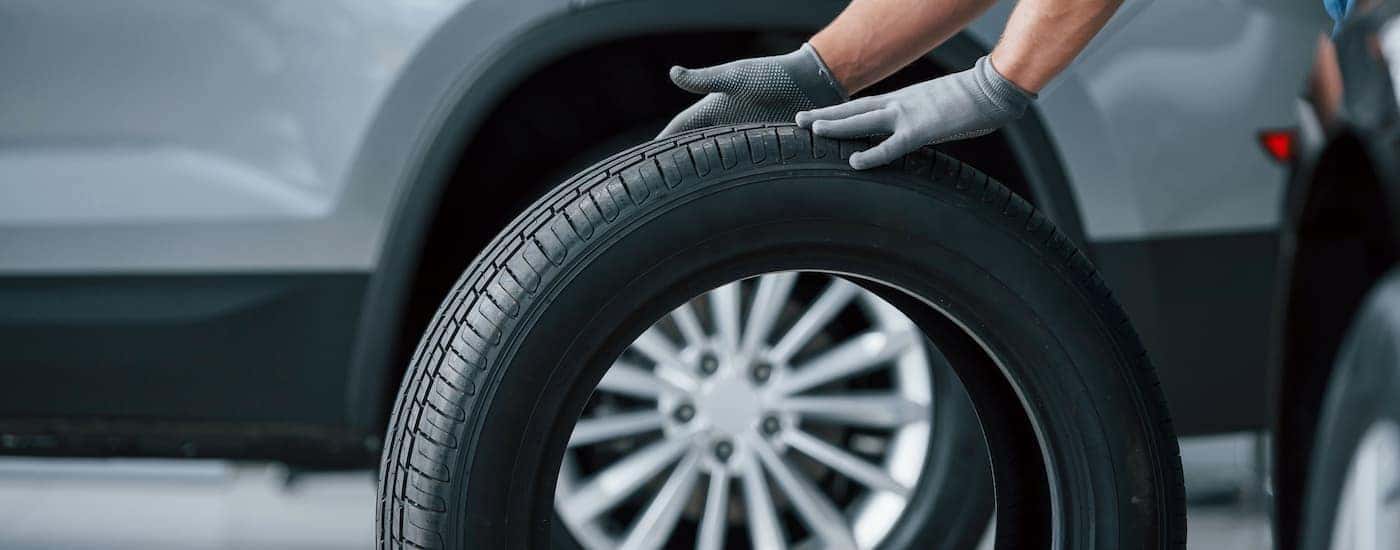 A mechanic rolling a tire mid change
