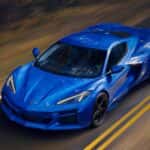 Blue 2026 Chevy Corvette E-Ray bird's eye view as it drives down the road