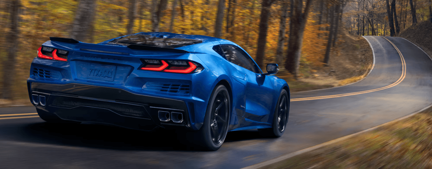 Blue 2026 Chevy Corvette E-Ray driving down a winding road