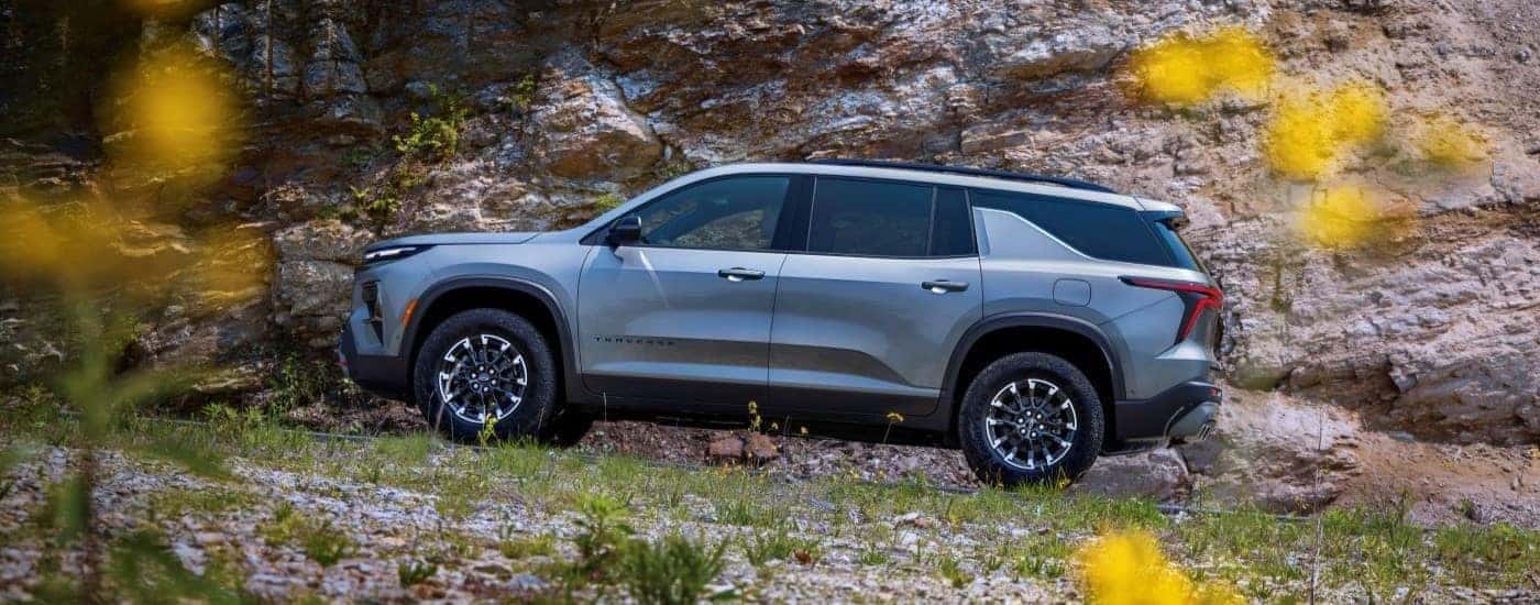 Silver 2026 Chevy Traverse driving up a hill
