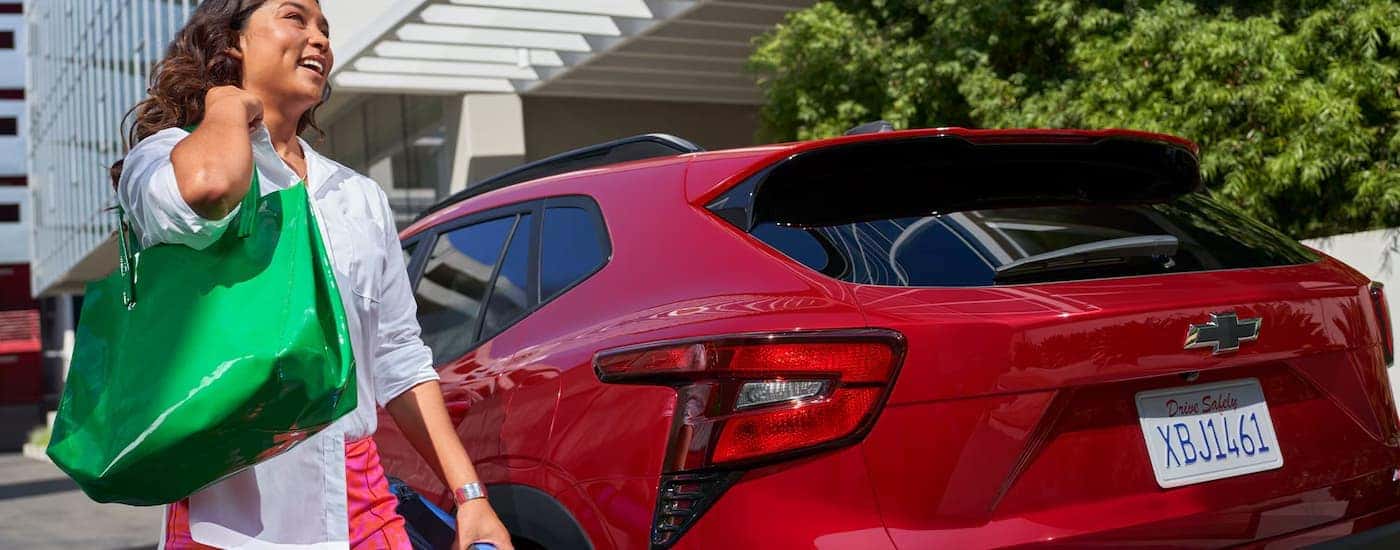 Woman walking past a red 2026 Chevy Trax