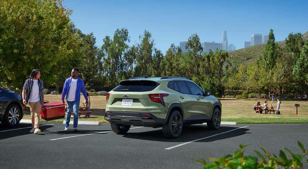 People walking near a green 2026 Chevy Trax ACTIV.