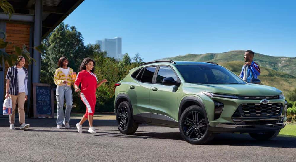 Green 2026 Chevy Trax parked with friends walking toward it