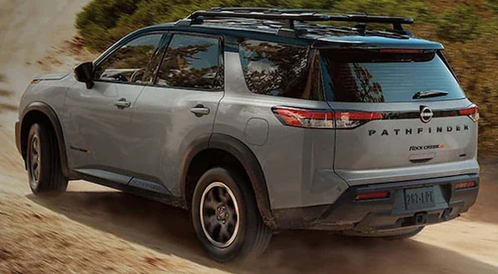 A gray 2023 Nissan Pathfinder driving on a dirt road.