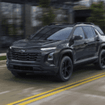 Black 2026 Chevy Equinox driving past a brick building