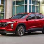Red 2026 Chevy Trax 2RS driving down a city street.