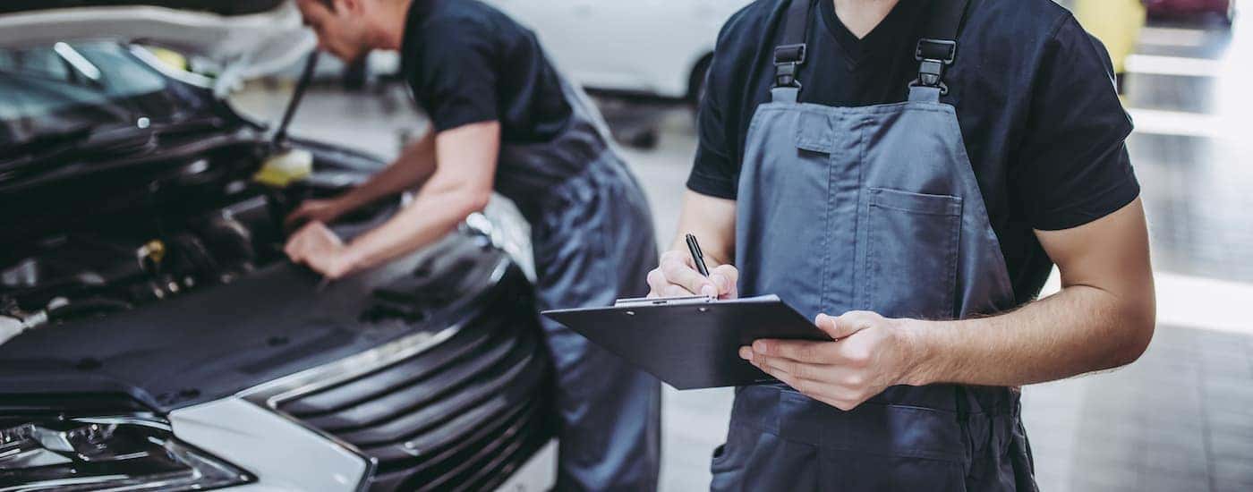 Two service technicians working on a vehicle