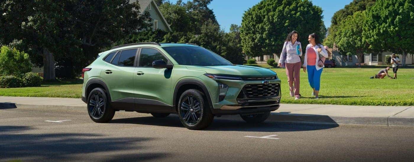 People approaching a green 2026 Chevy Trax ACTIV
